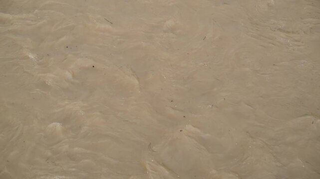 大雨で増水し激しく流れる茶色の濁流（災害・防災・気象）
