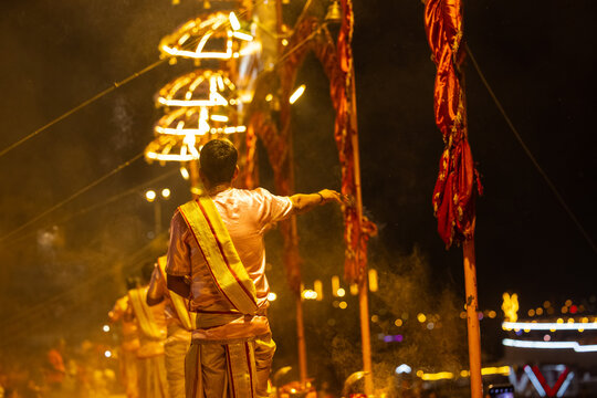 Ganga aarti, Portrait of young priest performing holy river ganges evening aarti at assi ghat in traditional dress with hindu rituals at dashashwamedh ghat.