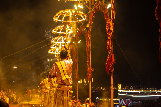 Ganga aarti, Portrait of young priest performing holy river ganges evening aarti at assi ghat in traditional dress with hindu rituals at dashashwamedh ghat.