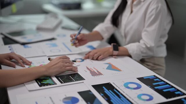 Business Meeting with Data Analysis Charts and Technology Devices in Office