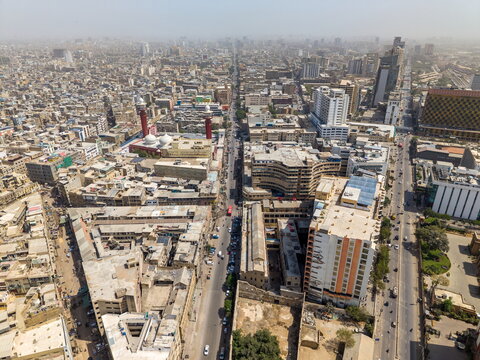 Aerial view of I.I. Chundrigar Road in Karachi, featuring dense urban architecture, busy streets, and a prominent mosque with minarets, Karachi, Sindh, Pakistan.