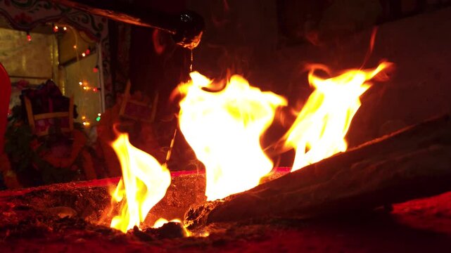 Sacred Hindu Havan Homam Yajna fire ritual being performed during a religious puja ceremony in India. The holy fire burns brightly in a traditional fire altar while devotees offer prayers