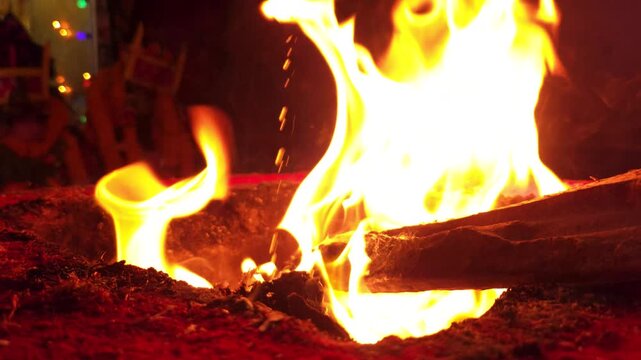 Sacred Hindu Havan Homam Yajna fire ritual being performed during a religious puja ceremony in India. The holy fire burns brightly in a traditional fire altar while devotees offer prayers