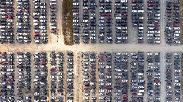 Aerial top down view of cars in a huge junkyard parking lot