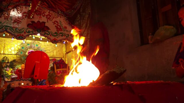 Sacred Hindu Havan Homam Yajna fire ritual being performed during a religious puja ceremony in India. The holy fire burns brightly in a traditional fire altar while devotees offer prayers