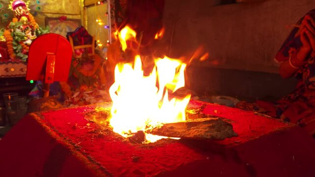 Sacred Hindu Havan Homam Yajna fire ritual being performed during a religious puja ceremony in India. The holy fire burns brightly in a traditional fire altar while devotees offer prayers