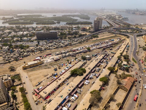 Aerial view of the urban landscape near I.I. Chundrigar Road, featuring railway tracks, shipping containers, dense buildings, and a highway bridge in Karachi, Sindh, Pakistan.