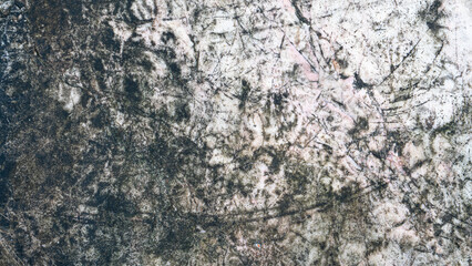 Fototapeta premium Abstract texture of a weathered dark stone surface. The rough material features organic patches of black mold moss and fine cracks creating a rustic pattern.