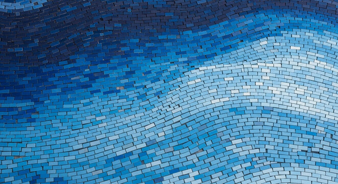 Wavy blue mosaic tile wall texture featuring a gradient of ceramic pieces from dark navy to light sky blue