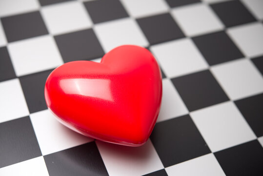 Close up red heart on chessboard background copy space. Love emotion, valentine day, online dating, customer focus in business, medical healthcare and so on concept.