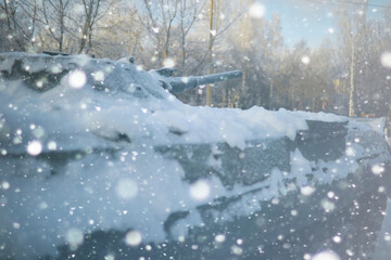 Fototapeta premium Military tank in a row. Battle tank in the snow on the roadside of highway. War in Ukraine in winter.
