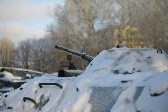Military tank in a row. Battle tank in the snow on the roadside of highway. War in Ukraine in winter.