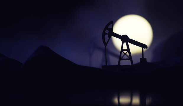 In the evening, the silhouette of oilfield derrick. Beam pumping unit under the night, closeup of photo