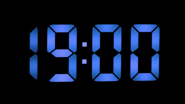 Digital clock showing the exact time as 18:59 in blue LED style numbers on a black background. Minute before 19:00, capturing the precise moment of transition.