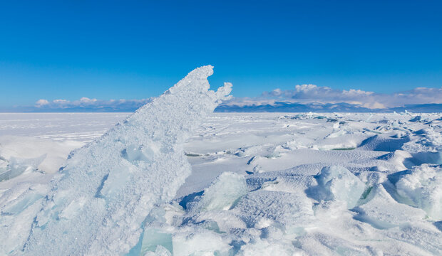 View of jagged ice shards on the frozen surface of Lake Baikal under a clear blue sky in Davsha, Buryatia, Russia.