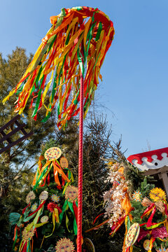 Maslenitsa celebrations. Colorful festive ribbons and a beautiful blue sky. The installation of the Maslenitsa pole