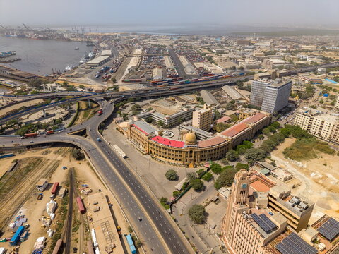 Aerial view of the Karachi Port Trust building and surrounding urban landscape near I.I. Chundrigar Road, featuring busy highways and dense city buildings in Karachi, Sindh, Pakistan.