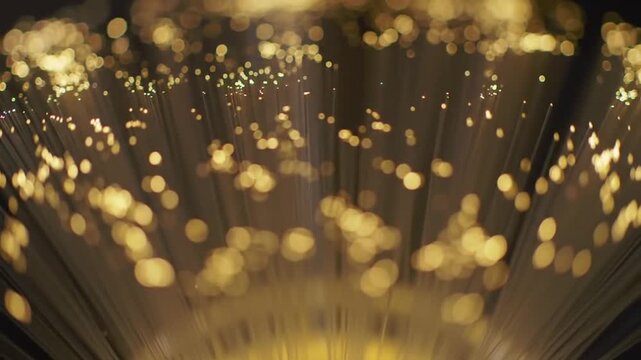 Sparkling Fiber Optic Strands Glowing with Golden Light and Bokeh Effect
