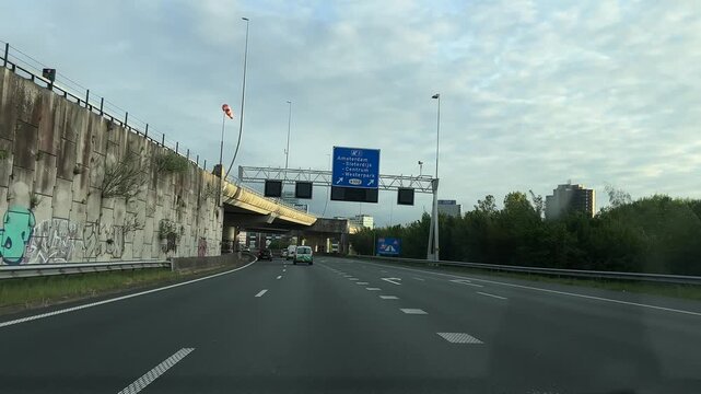 Amsterdam Netherlands highway, Urban highway approach with light traffic under cloudy sky