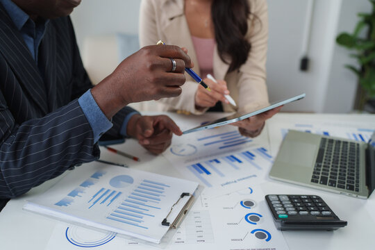 Business team analyzing financial data on tablet and papers