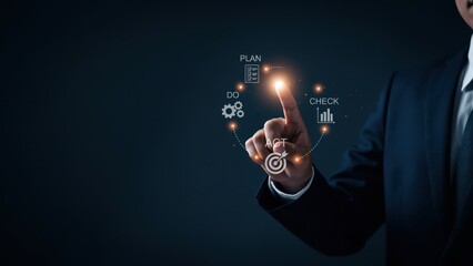Businessman hand pointing to a glowing circular diagram with PDCA cycle icons, symbolizing business planning and continuous improvement.