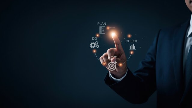 Businessman hand pointing to a glowing circular diagram with PDCA cycle icons, symbolizing business planning and continuous improvement.