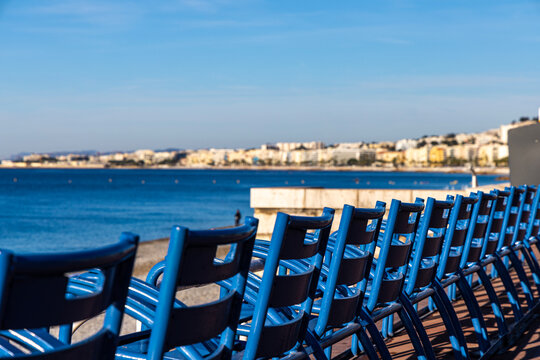 Blue chairs on the Promenade des Anglais in Nice, France.