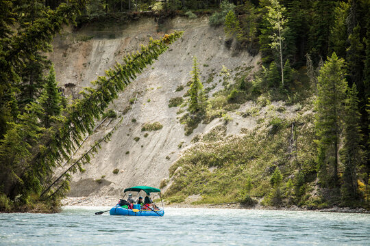 People on a raft float down a scenic river