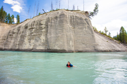 Woman enjoys a refreshing swim in a mountain river