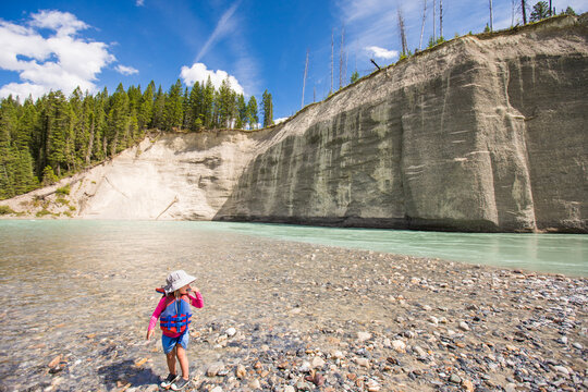 Young child explores a rocky glacial riverbank