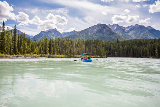 People rafting on a turquoise glacial river in the mountains