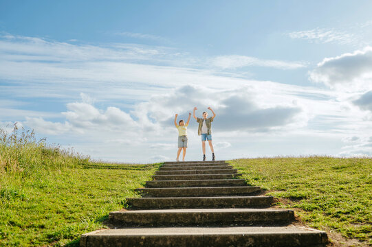 Children celebrating success together at top of outdoor steps
