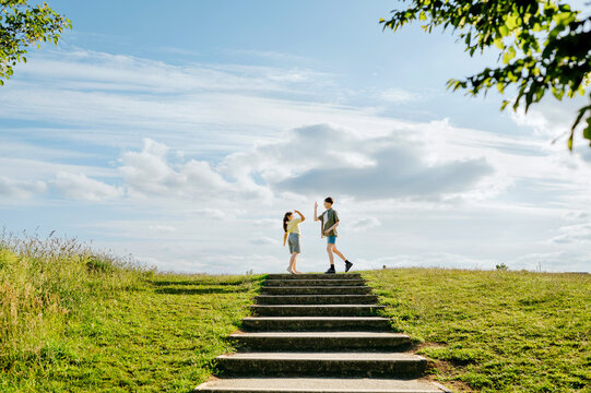 Children giving high five at top of outdoor steps