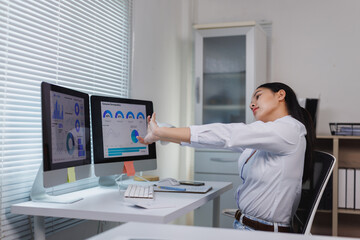 Fototapeta premium Businesswoman stretching at office desk during work break