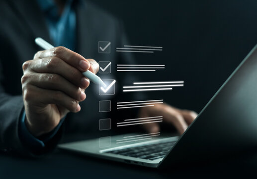 Business professional completing a digital checklist on laptop, representing task management, workflow optimization, project tracking, quality control, productivity improvement and business planning.