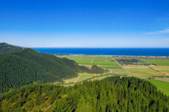 Forested mountains with farmland and coastal ocean view