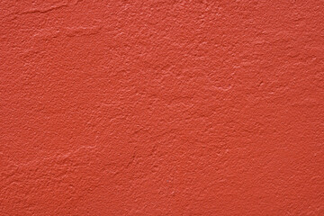 Fototapeta premium A solid painted stucco or plaster wall surface. A clean slate with a bright red hue to create a minimalist, industrial abstract background.