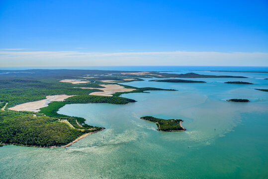 aerial view of small islands surrounded by turquoise-blue water at Southern end of Curtis Island