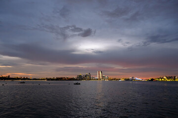 Fototapeta premium City skyline over calm water at dusk