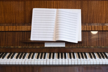 piano keyboard with blank sheet music notebook enables music practice session. classic piano keyboard with sheet music inspires musical learning © RollAndSnap