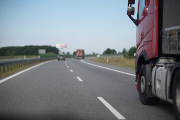Naklejka premium Red Semi Truck Driving on Highway. Modern Logistics and Freight Transportation. Heavy-duty truck on motorway transporting goods. Efficient freight transportation, logistics, and supply chain operation