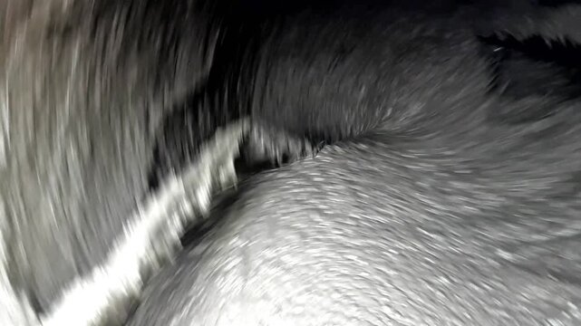Close-up of concrete mix in a mixer, textured surface with mud, rotating counterclockwise