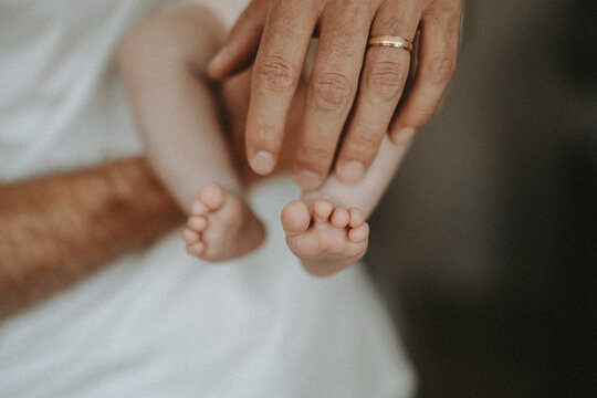 Petits pieds de nouveau-n&eacute; dans les mains d&rsquo;un parent