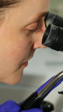 Gynecologist uses colposcope during cervical screening in clinic. Specialist studies tissue closely checking visual changes with focus