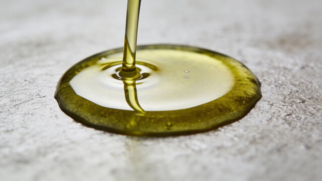 Fresh olive oil pouring on a surface in an agricultural setting during harvest season