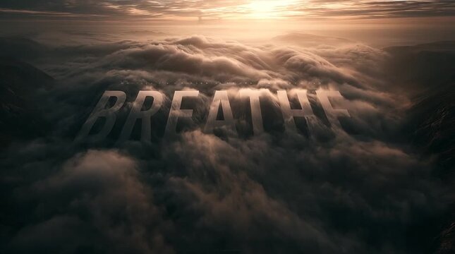 Clouds flow through a mountain valley at sunrise as enormous floating typography reading &ldquo;BREATHE&rdquo; forms from soft mist and golden light in a serene cinematic scene.