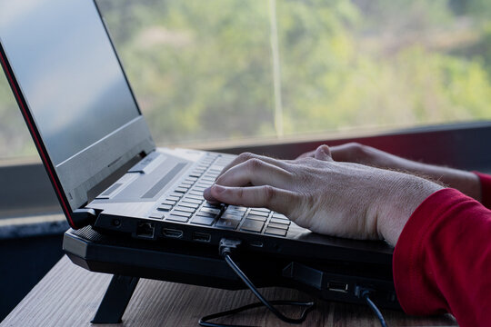 Close-up of hands typing on a laptop computer