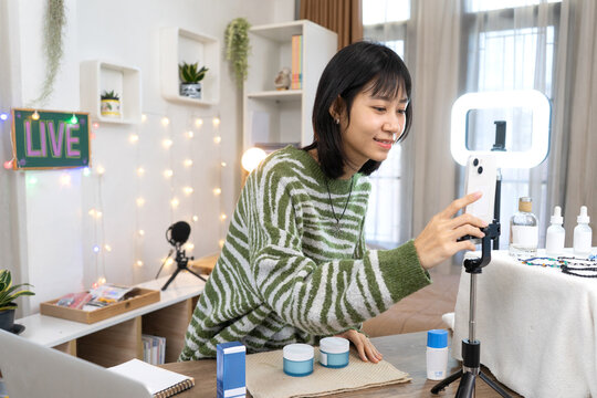 Young Online Seller Setting Up Smartphone for Live Product Streaming at Home Studio