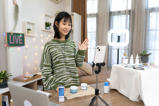 Young Online Seller Live Streaming engages with online while audience promoting Skincare Product Review from Home Studio