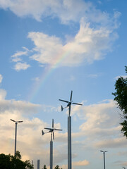 Fototapeta premium Two small residential wind turbines stand tall against a vivid sky
